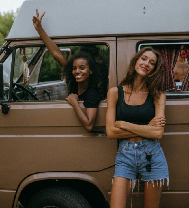 Two women on an off-road journey with a van, capturing the adventurous spirit of outdoor travel.