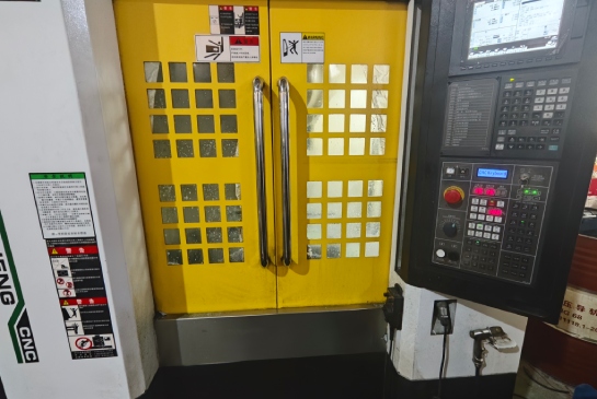 CNC machining center with control panel and safety enclosure for precision manufacturing