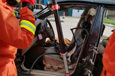 Firefighters using a rescue hydraulic jack with threaded piston rod for vehicle extrication during emergency response.